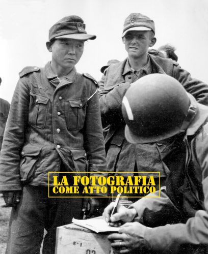 Un homme de la Engineer Special Brigade 5th ou 6th (arc blanc sur le casque)  inscrit les noms de prisonniers de la Wehrmacht. L'un d'eux très jeune est de type asiatique.
En fait il s'agit d'un Coréen Yang Kyoung-Jong né à Shin Euijoo en Corée le 3 mars 1920. Enrôlé dans l'armée japonaise du Kwantung en 1938, il est capturé par l'armée soviétique à Nomohan, enrôlé de force ou non puis recapturé par les Allemands à la bataille de Kharkov en 1943 puis enfin par les Américains à Utah. Libéré d'un camp de prisonniers en Angleterre en mai 45, il part s'établir en Amérique où il mènera une vie paisible sans jamais parler de son odyssée (on le comprend !). Il y meurt e 7 avril 1992.
Voir ici :
http://en.wikipedia.org/wiki/Yang_Kyoungjong
http://fr.wikipedia.org/wiki/Far_Away_:_Les_soldats_de_l%E2%80%99espoir
Information fournie par Stephen Ambrose dans son livre  D-Day June 6, 1944: The Climactic Battle of WWII. Simon & Schuster, 1994.
"Stephen Ambrose, an executive producer on the television mini-series that was based on his work, Band of Brothers, interviewed Robert Brewer(correct spelling?), who was a member of the first platoon of 'Easy Company' of the 506th Parachute Infantry Regiment, which parachuted near Vierville on June 6, 1944. According to this interview, on June 7, his platoon attacked and occupied a German bunker near the beach and captured four Asians in German uniform who spoke a strange language. They told him that they are Koreans and was conscripted to the Japanese army in 1938 and captured by the red army in 1939 in Nomonhan and again captured by Germans in the defense of Moscow in the winter of 1941. " 
Et :
http://www.dailymail.co.uk/news/article-2153688/Second-World-War--German-Japanese-soldier-stories-change-perception-ever.html
Et :
"In the early morning hours of June 6, 1944, members of E Company of the U.S. 506th Parachute Infantry Regiment dropped into and around Vierville and fought for several days with units attached